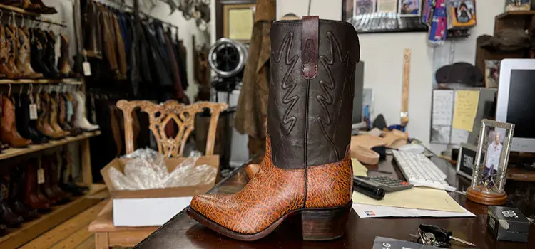 Pair of custom-colored cowboy boots in the shop being worked on.