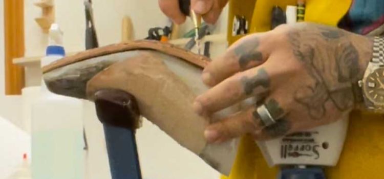 Professional craftsperson putting together a pair of custom cowboy boots.